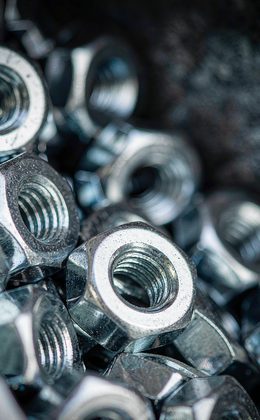 Macro cascade of shiny zinc-plated hex bolts and nuts